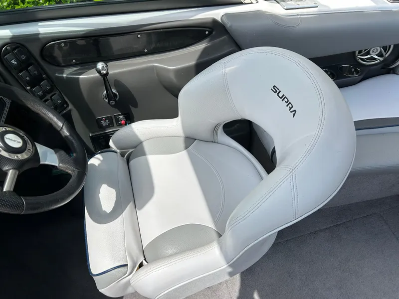 Slide: The Image of 2010 Supra Launch 21 V boat interior with steering wheel and branded seat. - 15