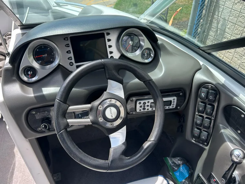 Slide: The Image of 2010 Supra Launch 21 V boat dashboard with steering wheel, gauges, and control panel. - 16