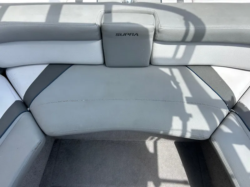 Slide: The Image of 2010 Supra Launch 21 V boat interior with gray and white seating. - 18