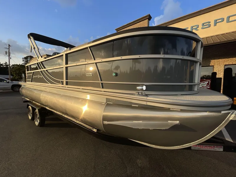Slide: The Image of 2025 South Bay S224RS pontoon boat with sleek design, parked outdoors at sunset. - 10