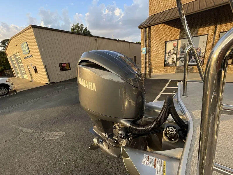 Slide: The Image of 2025 South Bay S224RS with Yamaha outboard motor, parked near a building at sunset. - 13