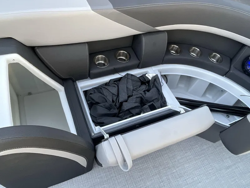 Slide: The Image of 2025 South Bay S224RS boat interior with storage compartments and cup holders. - 29