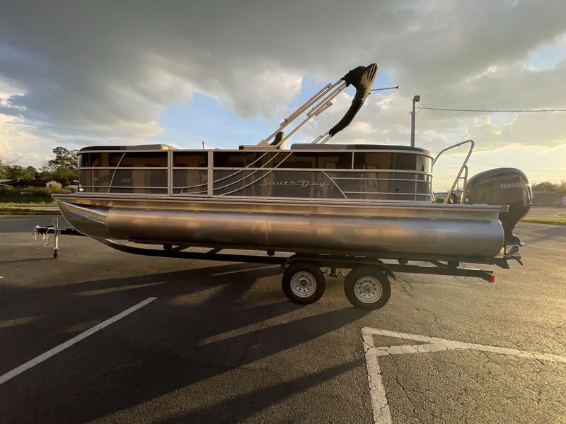 Slide: The Image of 2025 South Bay S224RS pontoon boat on trailer under cloudy sky. - 3