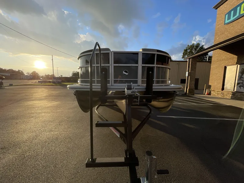 Slide: The Image of 2025 South Bay S224RS pontoon boat on trailer at sunset, dealership background. - 31