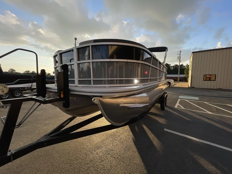 Slide: The Image of 2025 South Bay S224RS pontoon boat on trailer at sunset, parked in lot. - 32