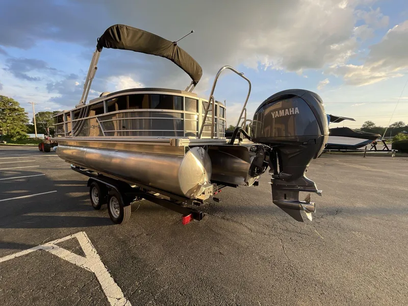 Slide: The Image of 2025 South Bay S224RS pontoon boat with Yamaha outboard motor on trailer, parked outdoors. - 34