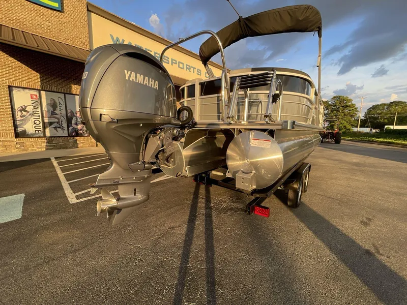 Slide: The Image of 2025 South Bay S224RS pontoon boat with Yamaha outboard motor, parked outside a watersports store. - 6