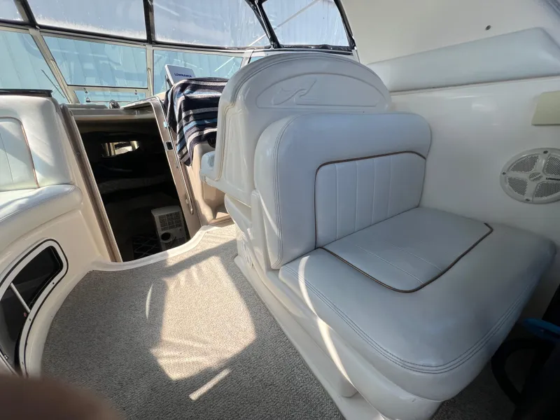 Slide: The Image of Interior of 1998 Sea Ray 290 Sundancer boat with white seating and blue canopy. - 7