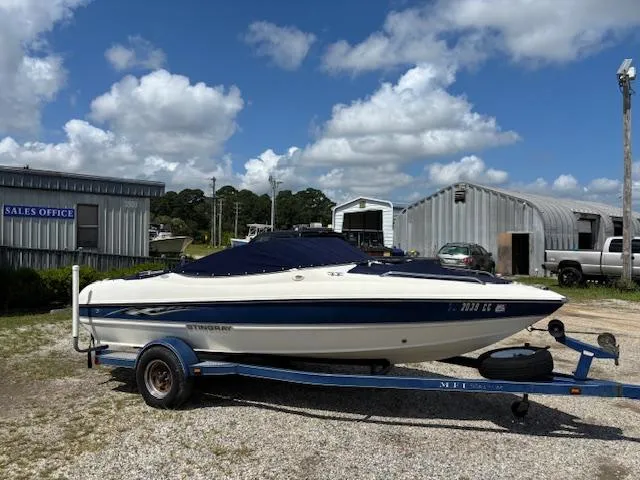 Slide: The Image of 2006 Stingray 185 LS/LX boat on trailer, parked outdoors under a cloudy sky. - 18