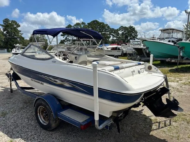 Slide: The Image of 2006 Stingray 185 LS/LX boat on trailer, parked outdoors under blue sky. - 2