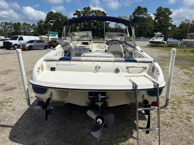Slide: The Image of 2006 Stingray 185 LS/LX boat, rear view, parked outdoors with trees in background. - 3