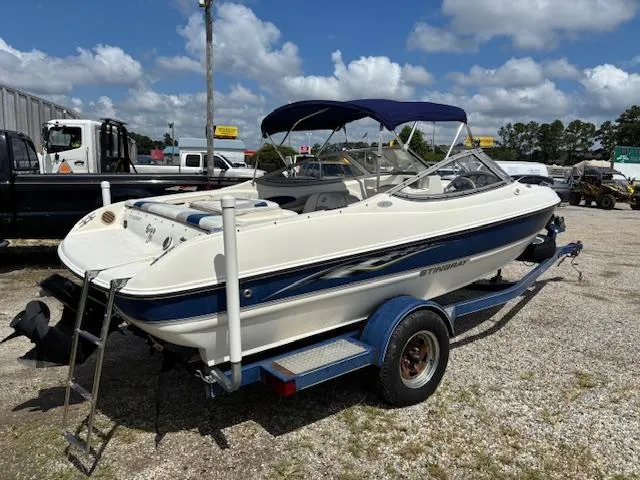 Slide: The Image of 2006 Stingray 185 LS/LX boat on trailer, parked outdoors under blue sky. - 4