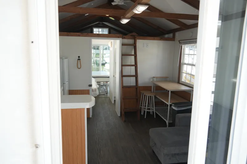 Slide: The Image of Interior of 2024 Catamaran Aqua Lodge, featuring modern kitchen, dining area, and loft ladder. - 11