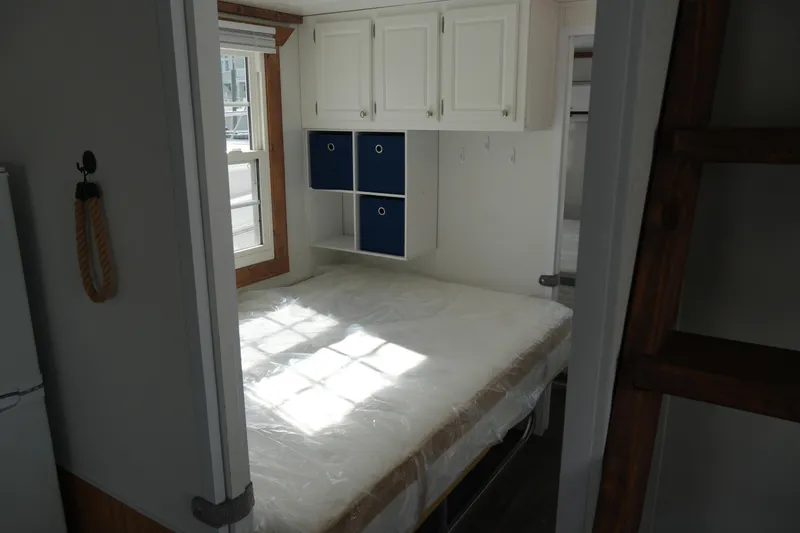 Slide: The Image of 2024 Catamaran Aqua Lodge bedroom with bed, window, and storage cabinets. - 19