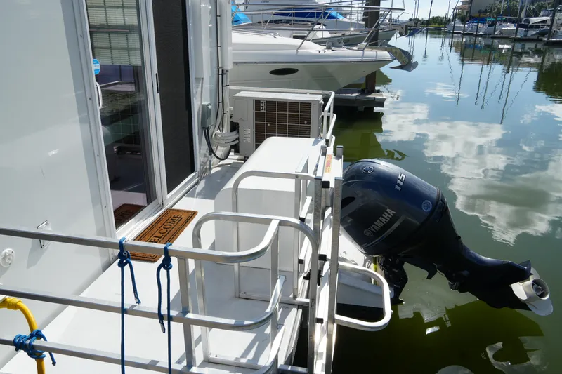 Slide: The Image of 2024 Catamaran Aqua Lodge with Yamaha motor docked at marina, reflecting on water. - 2