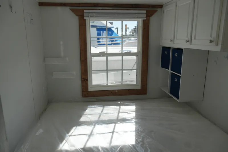 Slide: The Image of Interior of 2024 Catamaran Aqua Lodge with window, cabinets, and storage shelves. - 20
