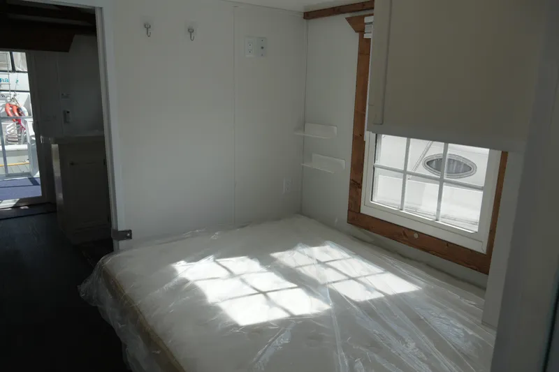 Slide: The Image of 2024 Catamaran Aqua Lodge interior with bed, window, and minimalistic design. - 21