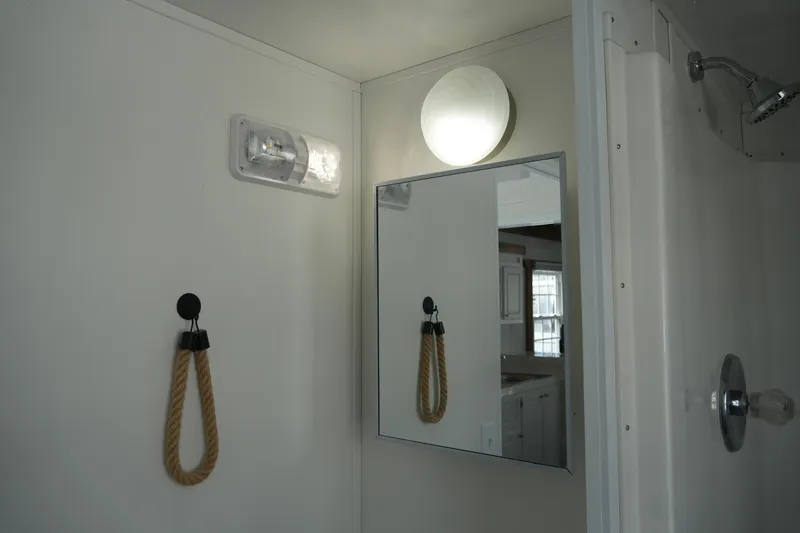 Slide: The Image of Bathroom interior of 2024 Catamaran Aqua Lodge with mirror, light, and showerhead. - 24