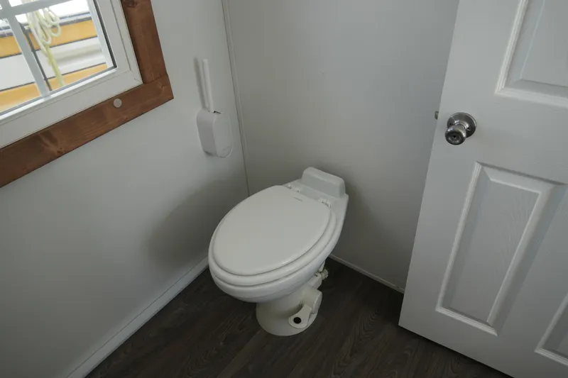 Slide: The Image of 2024 Catamaran Aqua Lodge bathroom with white toilet and wooden floor. - 27