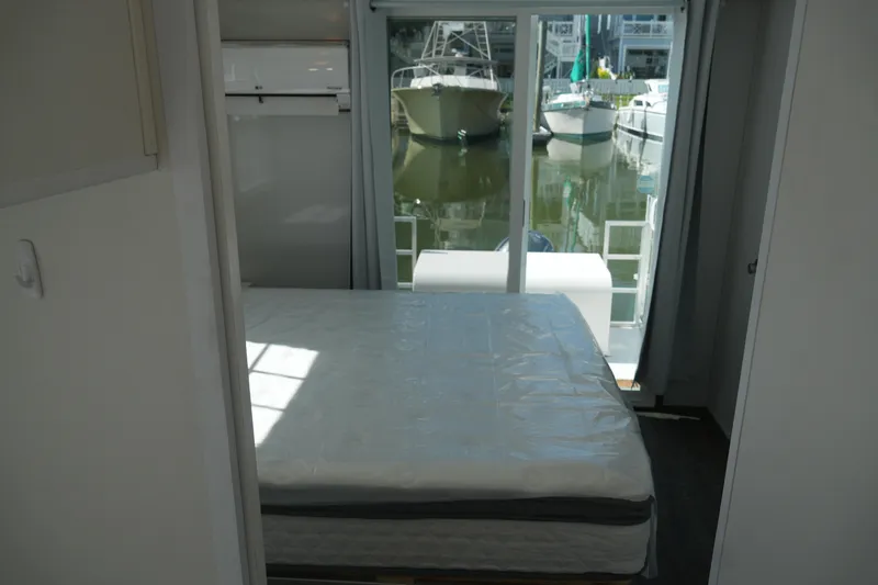 Slide: The Image of Interior of 2024 Catamaran Aqua Lodge with bed and marina view through sliding doors. - 30