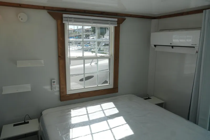 Slide: The Image of 2024 Catamaran Aqua Lodge interior with window, bed, and air conditioning unit. - 31