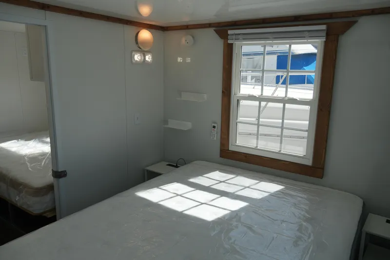 Slide: The Image of 2024 Catamaran Aqua Lodge bedroom interior with window, bed, and modern lighting. - 32