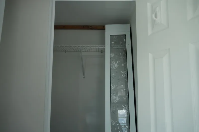 Slide: The Image of Empty closet with wire shelf and floral-patterned glass panel, Catamaran Aqua Lodge 2024. - 37