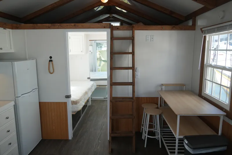 Slide: The Image of 2024 Catamaran Aqua Lodge interior with wooden ladder, dining area, and bedroom view. - 40