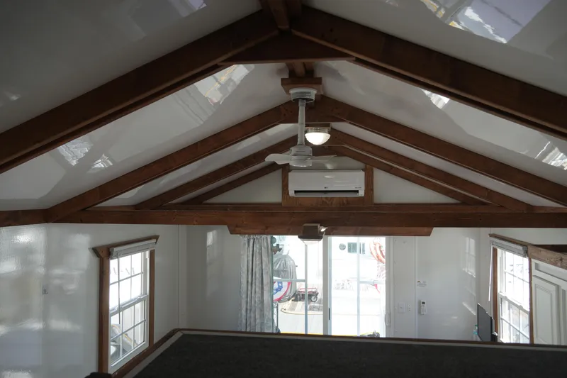 Slide: The Image of 2024 Catamaran Aqua Lodge interior with wooden beams, ceiling fan, and sliding glass doors. - 42