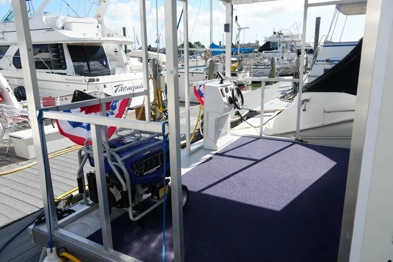 Slide: The Image of 2024 Catamaran Aqua Lodge docked, featuring deck area with generator and steering console. - 7