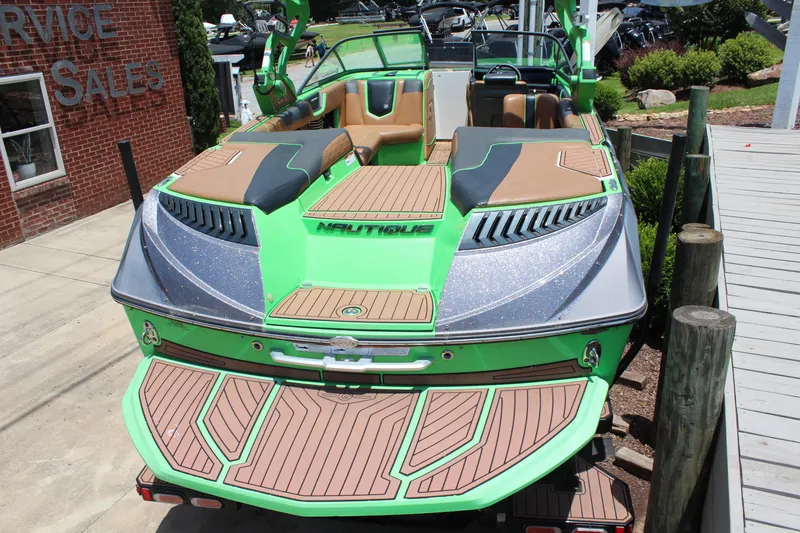 Slide: The Image of 2017 Nautique Super Air Nautique G23 boat, vibrant green, docked at service sales area. - 4