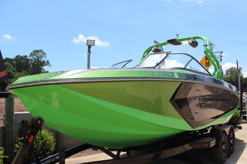 Slide: The Image of 2017 Nautique Super Air Nautique G23 boat in vibrant green on trailer, sunny day. - 7