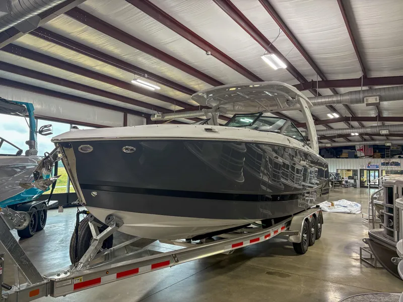 The Image of 2026 Four Winns H9 boat on trailer in indoor showroom. - 0