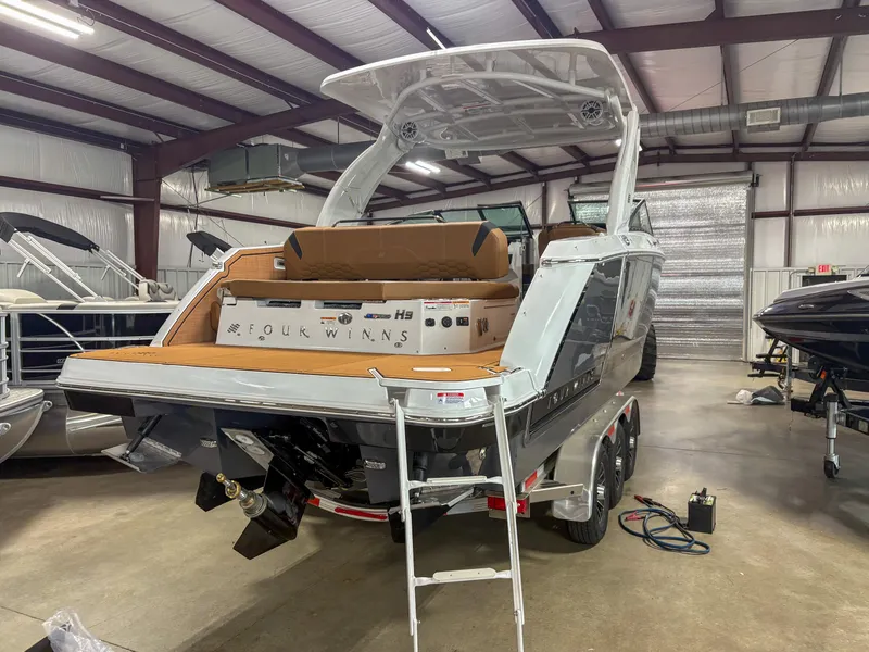 Slide: The Image of 2026 Four Winns H9 boat in a showroom, showcasing sleek design and modern features. - 2
