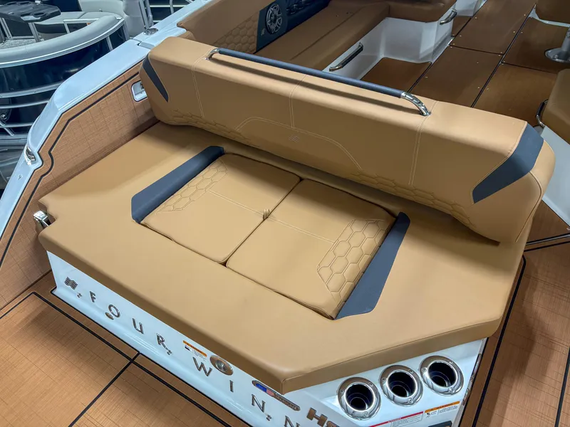 Slide: The Image of 2026 Four Winns H9 boat interior with tan seating and cup holders. - 21