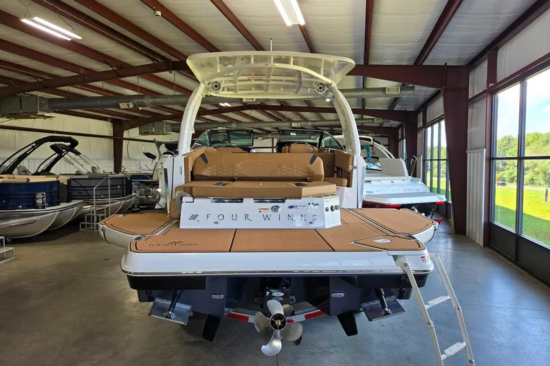 Slide: The Image of 2026 Four Winns H9 boat displayed in a showroom, featuring a sleek design and modern amenities. - 4