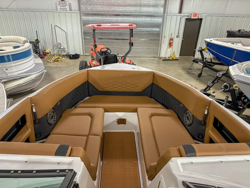 Slide: The Image of 2026 Four Winns H9 boat interior with tan seating in a showroom. - 5