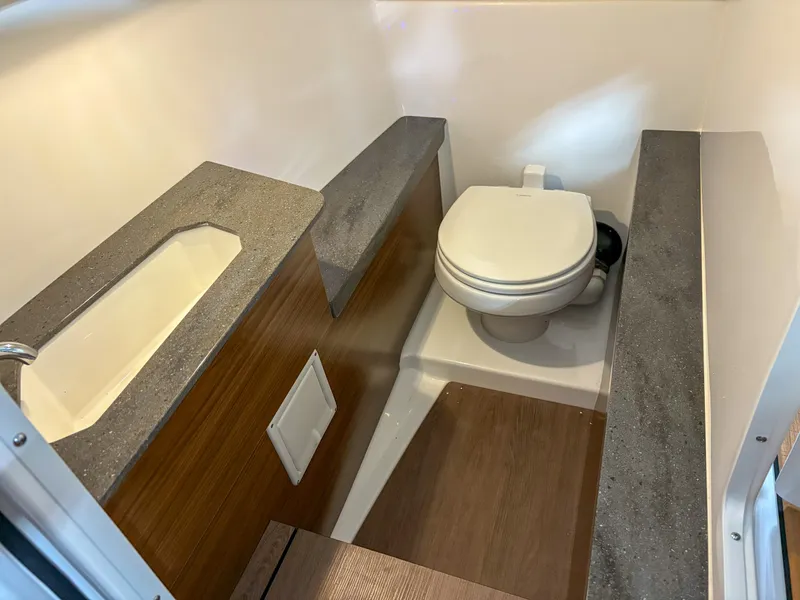 Slide: The Image of Compact bathroom in 2026 Four Winns H9 boat with modern fixtures and wood accents. - 8