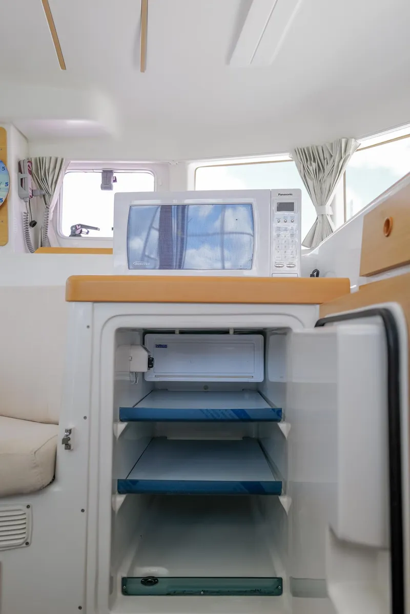 Slide: The Image of Interior of 2011 Lagoon 380 S2 yacht with open fridge and microwave. - 13