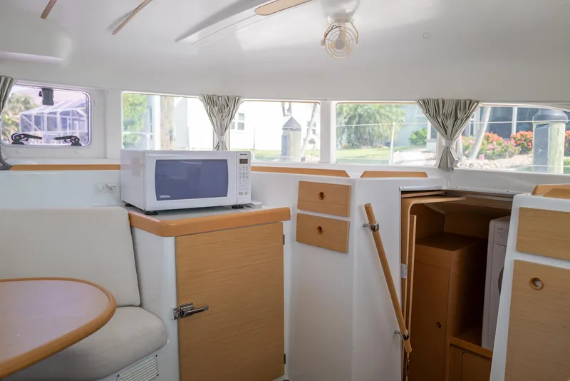 Slide: The Image of Interior of 2011 Lagoon 380 S2 yacht with microwave and wooden cabinetry. - 17