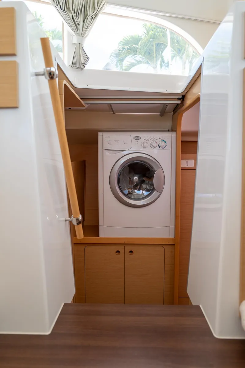 Slide: The Image of Washing machine inside Lagoon 380 S2 catamaran, 2011 model, with wooden cabinetry and natural light. - 23