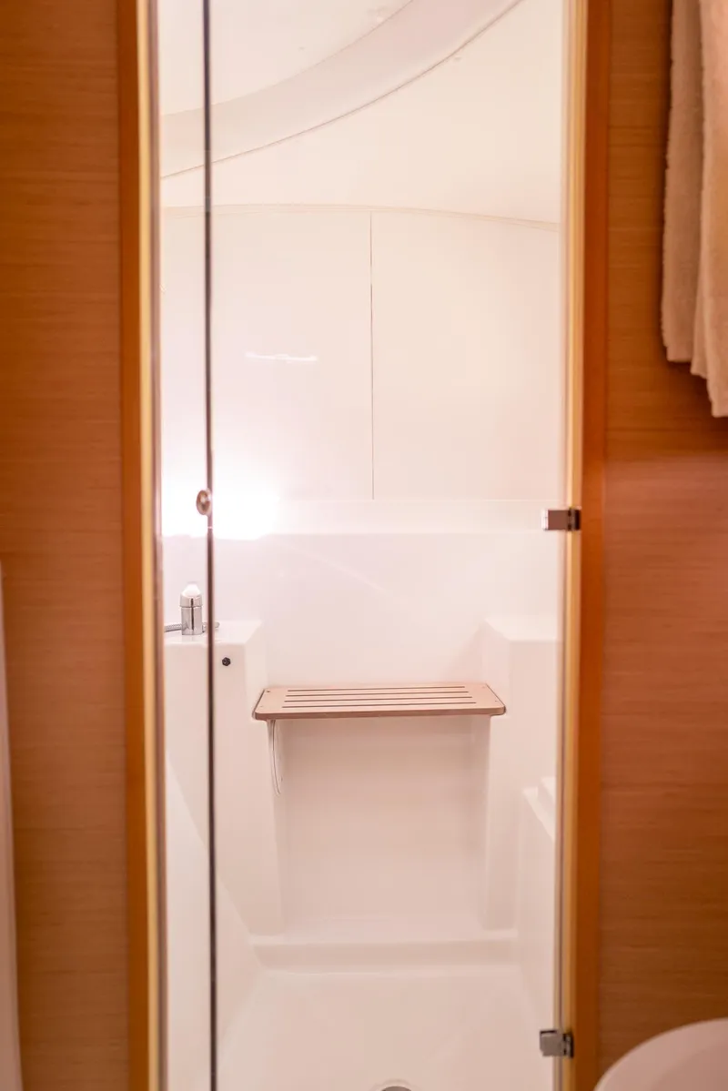 Slide: The Image of Interior of 2011 Lagoon 380 S2 yacht bathroom with wooden seat and glass door. - 24