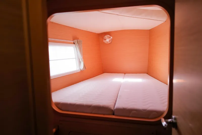 Slide: The Image of Cozy cabin interior of 2011 Lagoon 380 S2 catamaran with double bed and window. - 28