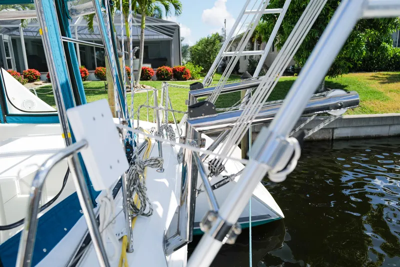 Slide: The Image of Lagoon 380 S2 catamaran docked, showcasing rigging and lush garden backdrop. - 31