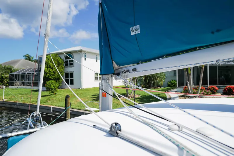 Slide: The Image of Sailboat Lagoon 380 S2, 2011 model, docked near waterfront homes, blue sky background. - 33