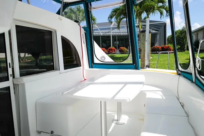 Slide: The Image of Lagoon 380 S2 catamaran cockpit with seating and table, surrounded by lush greenery. - 5