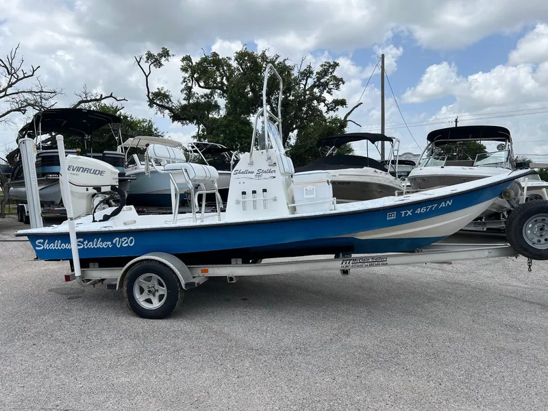 Slide: The Image of 2007 Shallow Stalker V20 boat on trailer, featuring Evinrude engine, parked outdoors. - 19