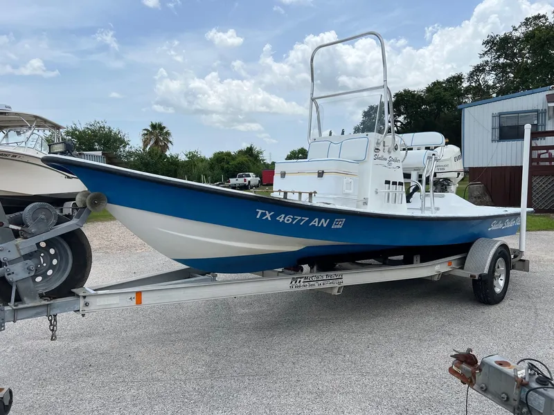 Slide: The Image of 2007 Shallow Stalker V20 boat on trailer, blue and white, parked outdoors. - 6