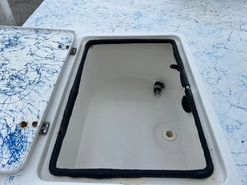Slide: The Image of Open storage compartment on 2007 Shallow Stalker V20 boat with blue splatter design. - 8