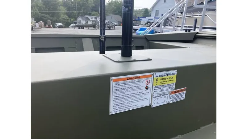 Slide: The Image of 2025 Lowe Roughneck RX1660 Tiller boat with warning and capacity labels displayed. - 6